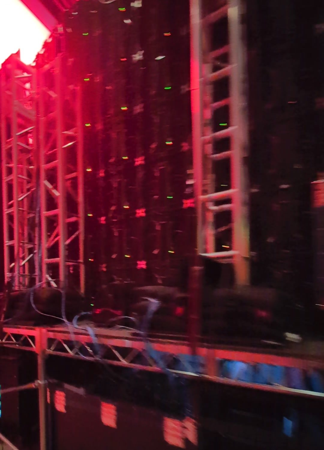 Backstage view of an LED wall on truss under red lighting