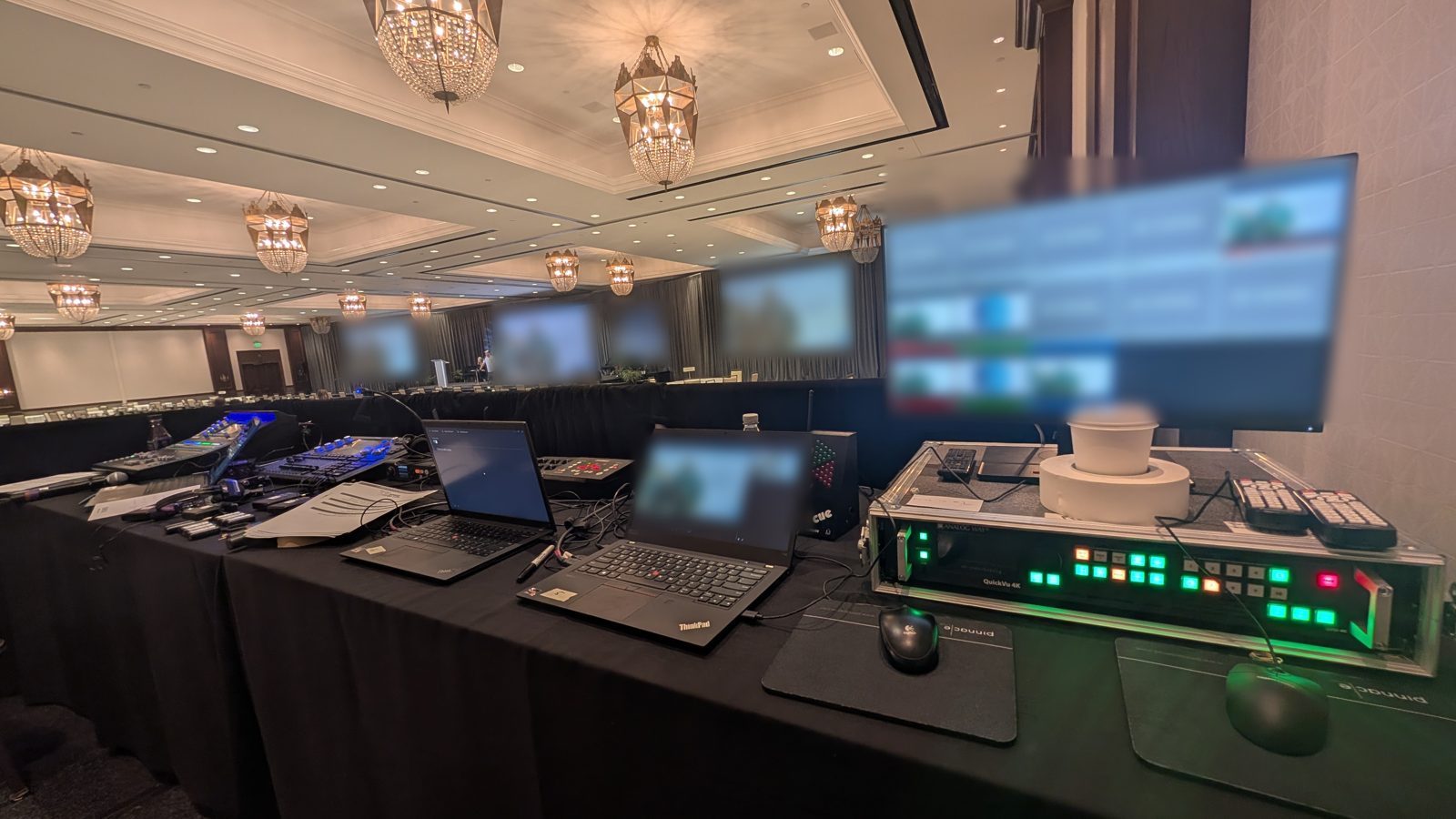 Video control table with switcher, multiviewer and playback laptops in a hotel ballroom